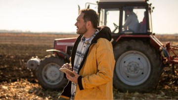 fermier pe camp cu tractor